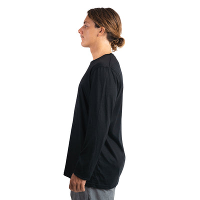 Side shot of Ottie Merino men's black long sleeve merino wool t-shirt on 173cm model who is wearing a size medium