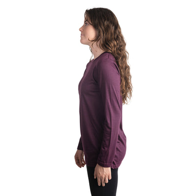Side shot of Ottie Merino women's Plum long sleeve merino wool t-shirt on 166cm model who is wearing a size small