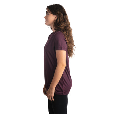 Side shot of Ottie Merino women's Plum short sleeve merino wool t-shirt on 166cm model who is wearing a size small